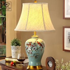 a lamp that is sitting on top of a table next to a vase with flowers