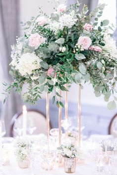 an elegant centerpiece with flowers and greenery