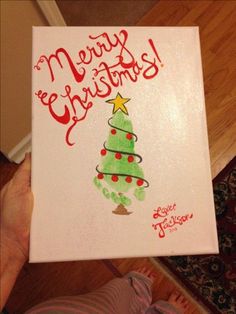 someone holding up a christmas card with a tree on it