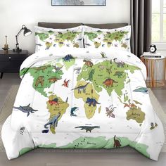 a bed covered in a white comforter and pillows with dinosaurs on the world map