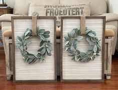 two wooden frames with wreaths on them in front of a couch