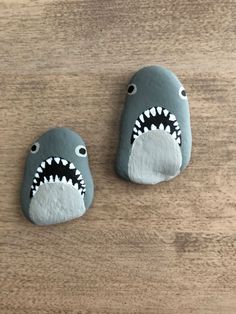 two rocks shaped like shark heads on top of a wooden table