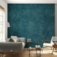 a living room filled with furniture and a wall painted in teal green stars pattern