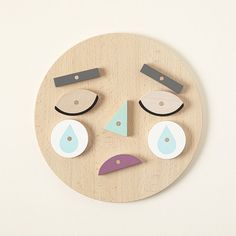 a wooden face with different shapes and colors