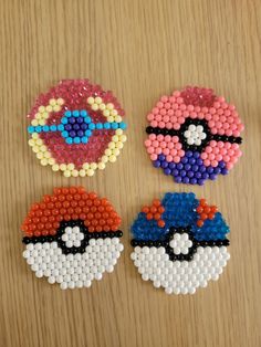 three pieces of bead art on a wooden surface