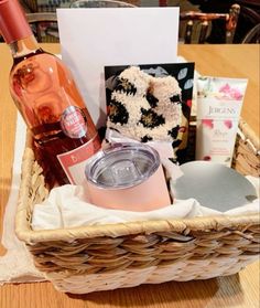 a basket filled with lots of different items on top of a wooden table next to a bottle