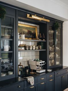 a kitchen with black cabinets and gold trim