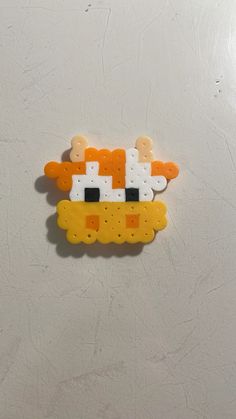 an orange and white cat brooch sitting on top of a table