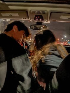 two people sitting in the back seat of a car