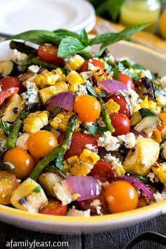 a colorful salad with tomatoes, corn and feta cheese