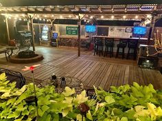 a wooden deck with tables and chairs covered in lights