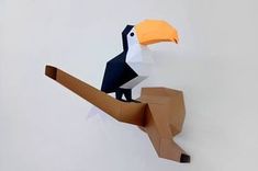 an origami bird sitting on top of a paper toucan shaped animal