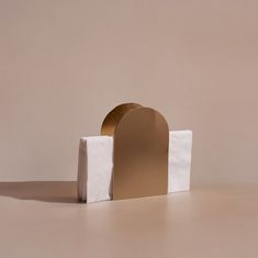 a white and gold object sitting on top of a brown floor next to a wall