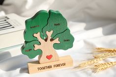 a wooden toy tree with the words together forever on it and a book next to it