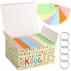 a box filled with lots of different colored papers and paper clips next to each other