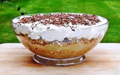 a dessert is sitting on top of a wooden table in front of some green grass