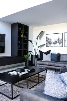 a living room filled with furniture and a flat screen tv mounted to the side of a wall