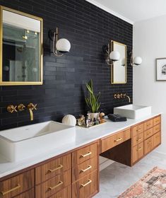 a bathroom with two sinks and mirrors on the wall next to a rug in front of it