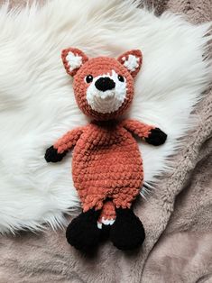 a crocheted stuffed animal laying on top of a blanket