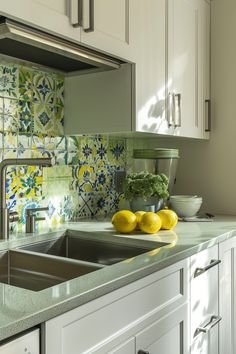 two lemons are sitting on the counter in front of a kitchen sink and dishwasher