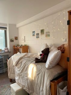 a teddy bear sitting on top of a bed in a room with white walls and lights