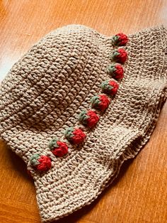 a crocheted hat with red flowers on it