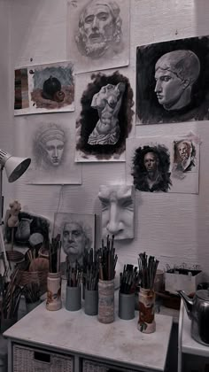 an artist's studio with many drawings on the wall