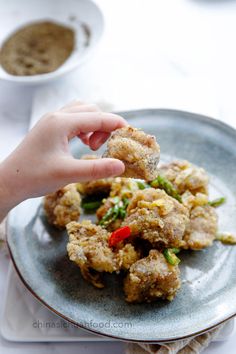 a person is reaching for some food on a plate