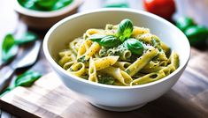 a white bowl filled with pasta and pesto on top of a wooden cutting board