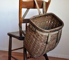 an old wooden chair with a basket on it