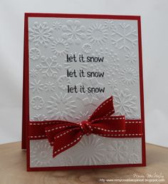 a handmade christmas card with a red bow on the front and white snowflakes on the back