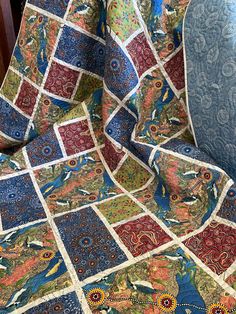 a blue chair sitting next to a colorful quilt