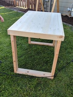 a wooden table sitting on top of a lush green field