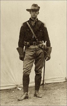 an old black and white photo of a man in uniform with his hat on, holding two canes