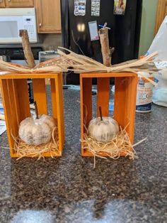 two pumpkins are placed in wooden crates on the kitchen counter, ready to be used as decorations