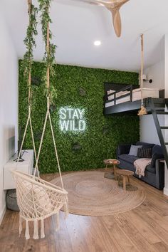 a room with a bed, chair and green wall in the background that says stay wild