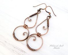 "Handmade copper earrings. These are my favorite pair to wear! * Metal: solid copper * Dimensions: They hang 2.5\" from the piercing and are 7/8\" wide. * Each pair is handmade and will vary slightly from those in the photos. * Clear coated to help preserve the antiqued finish. Solid copper wire was used to form these earrings. The ear wires are also solid copper. They were hammered for strength and antiqued for a warm, rustic look. A clear coating helps prevent further tarnishing and gives them Bohemian Wrap Earrings With Copper Ear Wire, Bohemian Copper Wire Wrapped Earrings, Handmade Copper Wrap Earrings, Handmade Unique Copper Wrap Earrings, Unique Handmade Copper Wrap Earrings, Bohemian Copper Wrap Earrings, Bohemian Rose Gold Wire Wrapped Earrings, Twist Jewelry, Gemstone Brooch