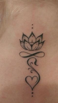 a woman's back neck with a lotus tattoo on it