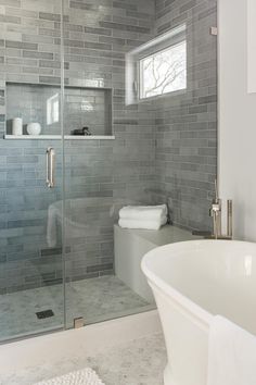 a white bath tub sitting next to a walk in shower