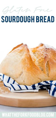 a loaf of sourdough bread sitting on top of a cutting board next to a blue and white towel