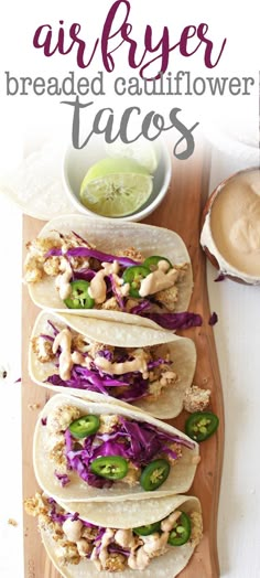 three chicken tacos on a cutting board with sauce