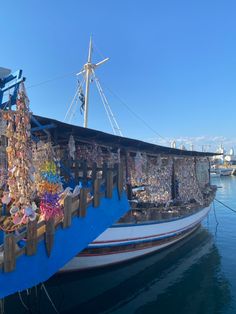 there is a boat with many items on it in the water next to a pier