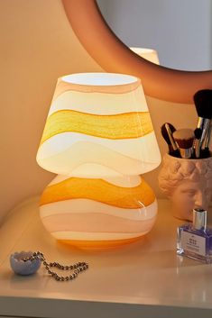 a lamp that is sitting on a table next to some makeup brushes and other items