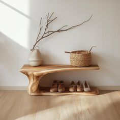 a wooden shelf with shoes on it next to a basket and tree branch in the corner