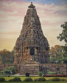 a large stone structure sitting on top of a lush green field