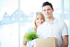 a man and woman holding a box with a plant in it