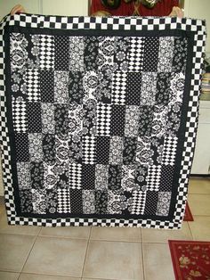 a large black and white quilt on the floor