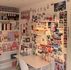 a white desk sitting in front of a book shelf filled with lots of books and pictures