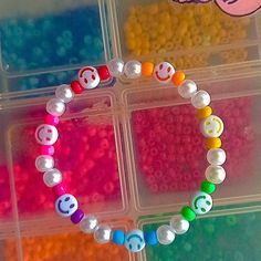 the beads are arranged in different colors and shapes to make a beaded heart bracelet