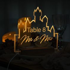 the illuminated table and mr & mrs sign is displayed on a table next to candles